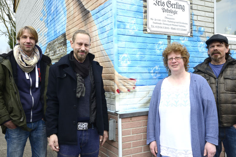 Iris Gerling mit dem Projektkoordinator Detlef Kraas (r.), Projektbgeleiter Volker Kranefeld (l.) und dem Graffiti-Künstler Roberto Trementino vor ihrer Praxis in der Hagener Straße 100.